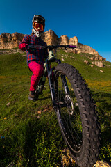Nature and mountain biking, morning training and extreme sports on the trail. A man cycling outdoors against a backdrop of rocky mountains
