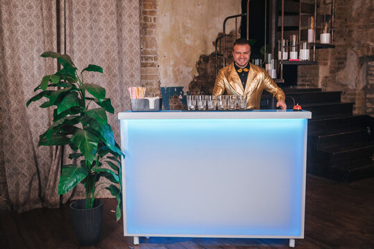 Bartender in gold jacket starts preparing cocktails