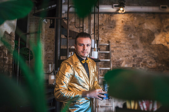 Bartender in a stylish gold jacket preparing drinks