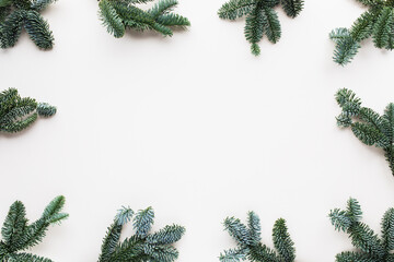 Christmas card with fir branches top view. White festive background for winter and New Year holidays.