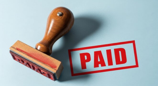 Wooden stamp affirms transaction status with bold red paid impression white background