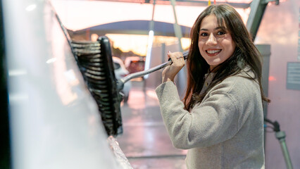 Woman using brush at car wash station
