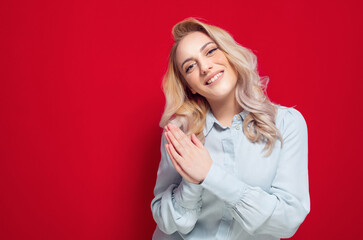 Please. Prayer woman holds her hands in a prayer gesture, begging for something, isolated on red background. Please concept
