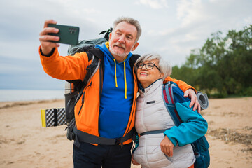 Hiking tourism adventure. Senior couple making selfie enjoying outdoor recreation hiking. Old people backpackers hikers taking photo enjoy walking hike trekking active vacation beauty of nature
