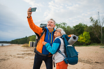 Hiking tourism adventure. Senior couple making selfie enjoying outdoor recreation hiking. Old people backpackers hikers taking photo enjoy walking hike trekking active vacation beauty of nature
