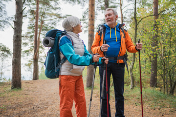Hiking tourism adventure. Senior couple man woman enjoying outdoor recreation hiking in forest. Happy old people backpackers hikers enjoy walking hike trekking tourism active vacation beauty of nature