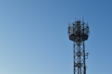 Looking up at a mobile phone tower on a sunny day.	