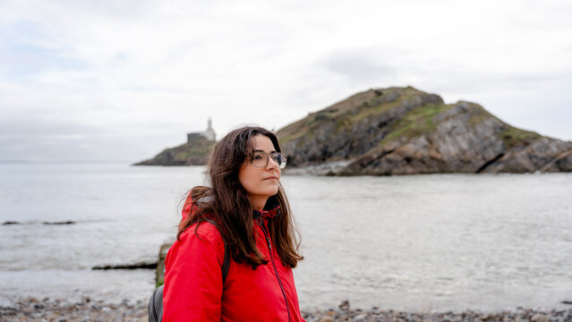 Woman walking on Mumbles Pier with lighthouse view