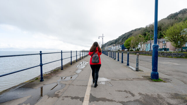 Woman walking on Mumbles promenade with sea view