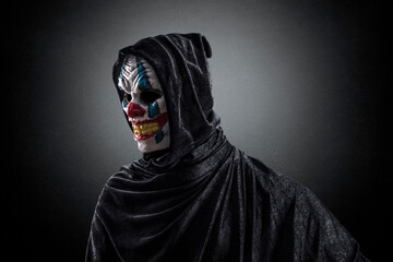 Portrait of a scary clown over dark misty background with clipping path