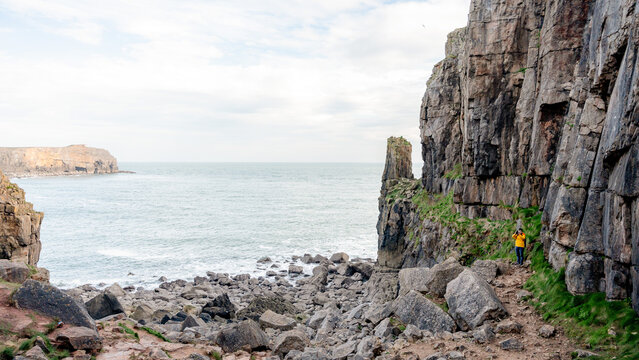 Man photographing rocky cliffs at coastal national park