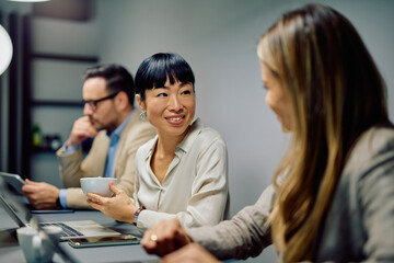 Diverse business professionals collaborating, communicating, and networking during a refreshment break in a modern office meeting