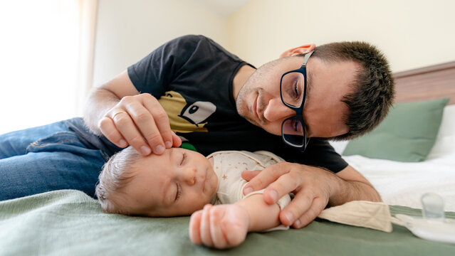 Father bonding with baby on a cozy bed at home