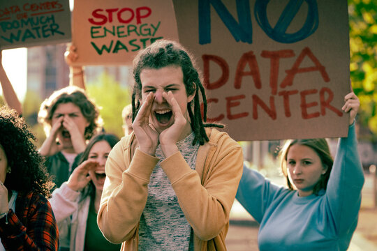 Youth activists protesting against data centers with signs about water waste and energy consumption