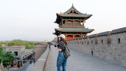 Woman exploring the Pingyao city wall at sunset