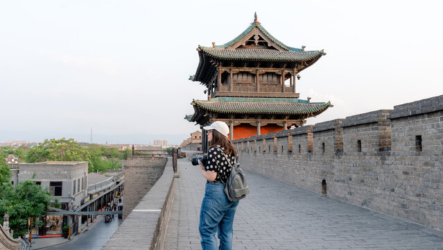 Woman exploring the Pingyao city wall at sunset