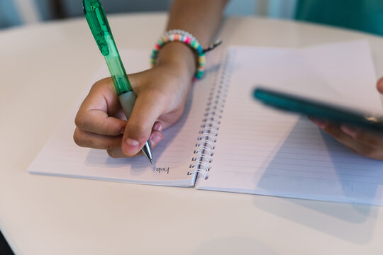 Girl doing homework with pen and notebook