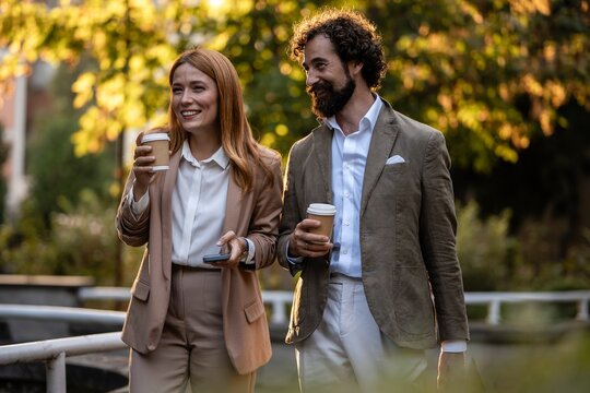 Business people walking and talking during coffee break outdoors