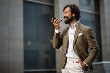 Businessman using smartphone voice assistant in city