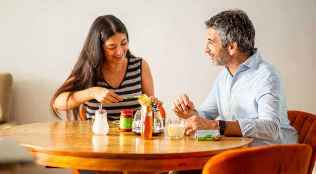 Smiling couple preparing toast together during cozy breakfast time - Powered by Adobe
