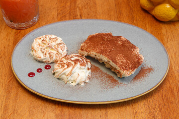 Tiramisu fait maison avec chantilly, posé sur une table en bois. Dessert italien. 