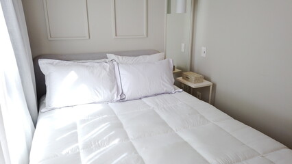 Elegant Bedroom with Cozy Bed, Light Decor, and Warm Sunlight