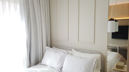 Elegant Bedroom with Cozy Bed, Light Decor, and Warm Sunlight