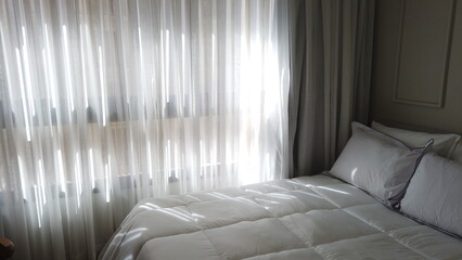 Elegant Bedroom with Cozy Bed, Light Decor, and Warm Sunlight 