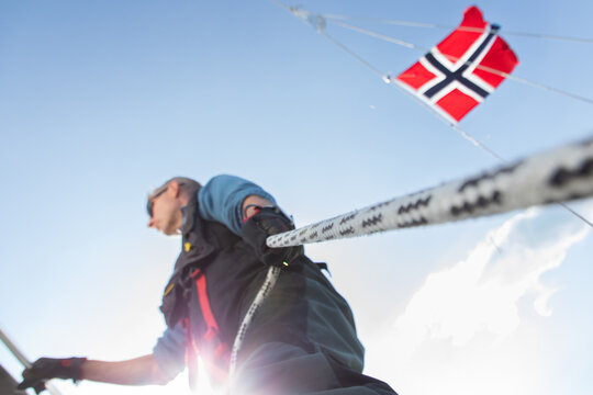 Man sailing amidst Norwegian waters under sunny skies