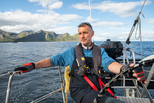 Man sailing on calm waters in scenic Norwegian landscape - Powered by Adobe
