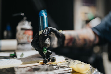 A tattoo artist wearing gloves operates a tattoo machine, inking a design on a client's skin. The close-up captures precision, focus, and the professional studio environment.