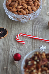 Various Christmas decorations, cookies, chocolate and nuts on wooden background. Selective focus.