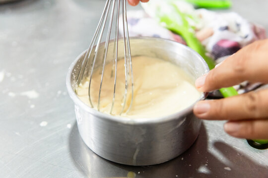 Person mixing batter in metal bowl for cooking class