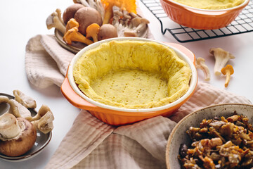 Quiche with chanterelle mushrooms, oyster mushrooms, button mushrooms, and cheese in two serving dishes