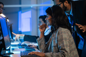 customer service agent team with headset typing on a computer keyboard. Modern call center office, providing efficient tech support, telemarketing and online communication during a late-night shift