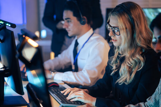 customer service agent team with headset typing on a computer keyboard. Modern call center office, providing efficient tech support, telemarketing and online communication during a late-night shift