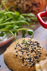 Gourmet Liver Pate Appetizer with Sesame Seed Bagels and and Fresh Pea Shoots on Rustic Wooden Board