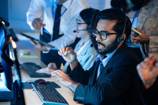 Customer service agent wearing a headset actively working diverse team call center. Technical support, telemarketing, work collaboration. consulting service. Group working overtime.
