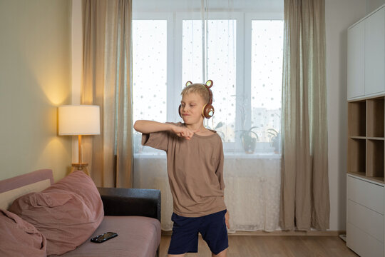 Young boy dancing with headphones in living room