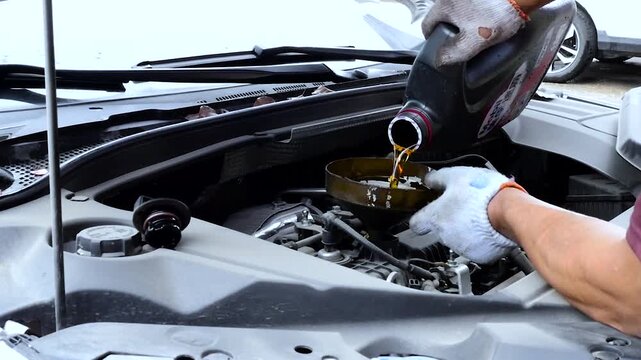 Mechanic Changing Motor Oil in Car Engine - Automotive Maintenance Service