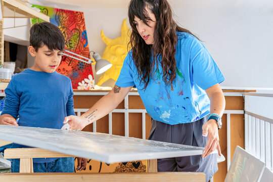 Visual artist teaching young student in creative art studio setting