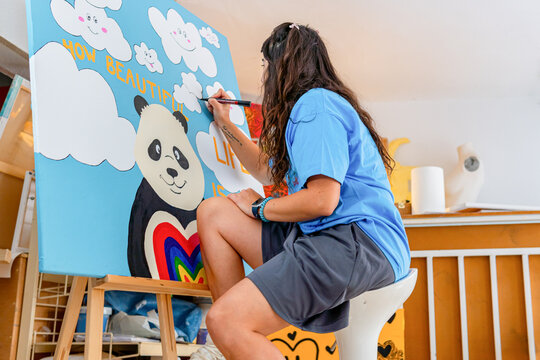 Artist creating colorful painting in workshop setting