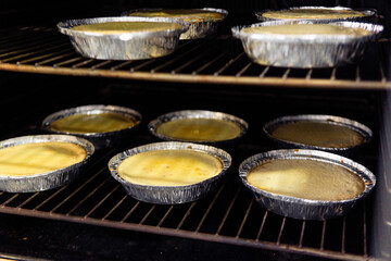 Small desserts baking in foil containers inside an oven