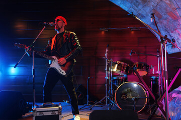 Fototapeta premium Handsome man playing electric guitar on stage