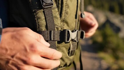 Close up outdoor activity preparation hand fastening backpack buckle for adventure journey
