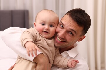 Happy father with his cute baby at home