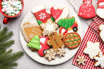 Tasty gingerbread cookies, marshmallows and Christmas decor on white textured table, flat lay