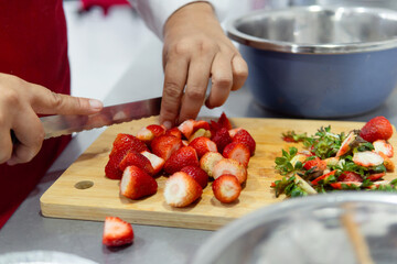 Chef hands chopping fresh strawberries for cooking class
