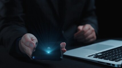 A close-up view of a hand holding a smartphone displaying a cloud storage concept, illustrating digital file transfer with visual elements representing technology and data management. Qubit - Powered by Adobe