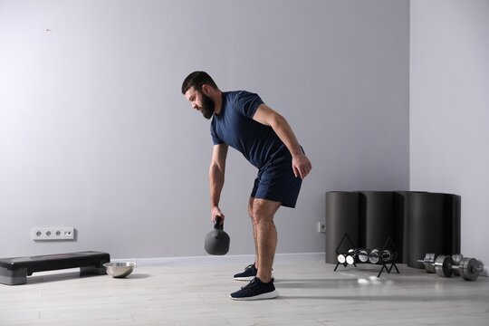 Strong man exercising with kettlebell in gym